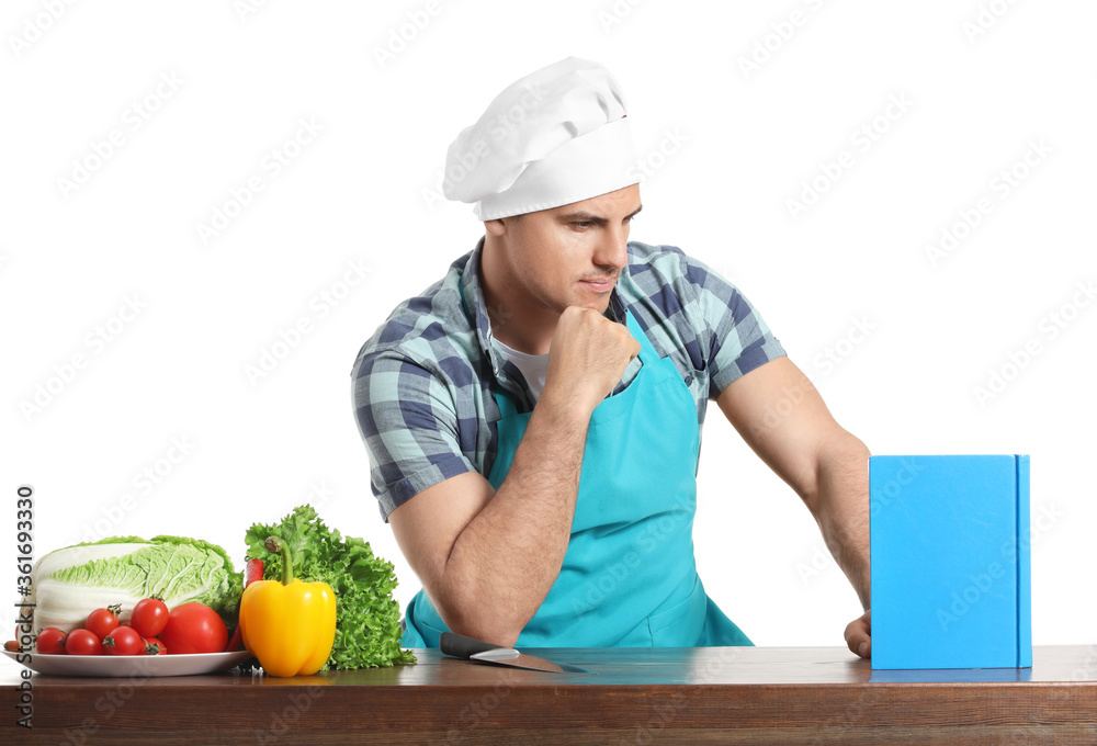 Young man with recipe book on white background