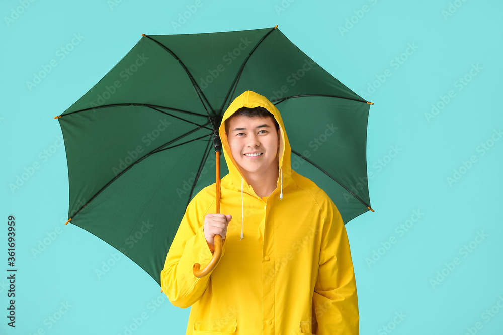 穿着雨衣、打着雨伞的亚洲年轻人