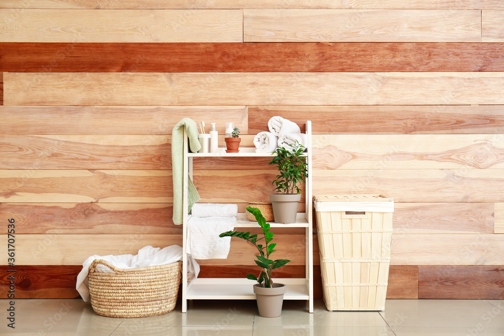 Rack and baskets with towels and supplies in bathroom