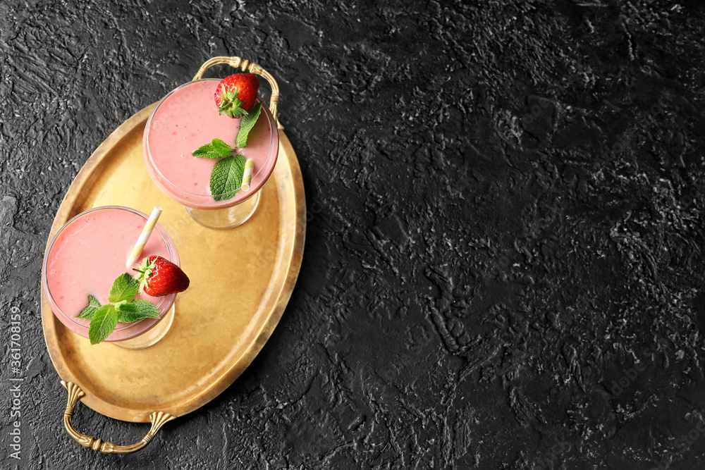 Glasses of tasty strawberry smoothie on dark background