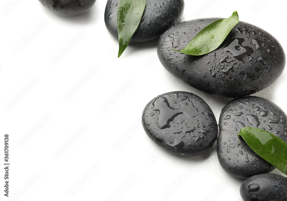 Spa stones and bamboo leaves on white background