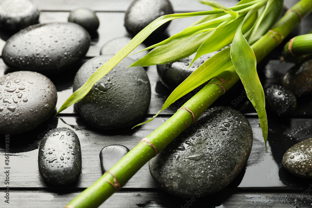 Spa stones and bamboo on dark wooden background