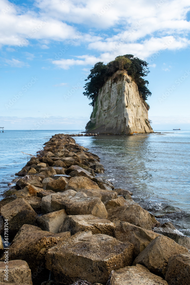 Mitsukejima diamond shaped island with trees on top of the rock, view with stone pier, on Noto Penin