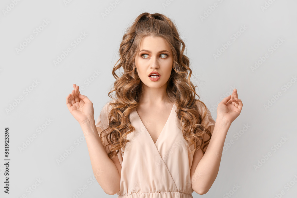 Beautiful young woman with stylish hairdo on grey background