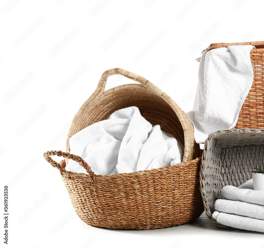 Wicker baskets with towels on white background