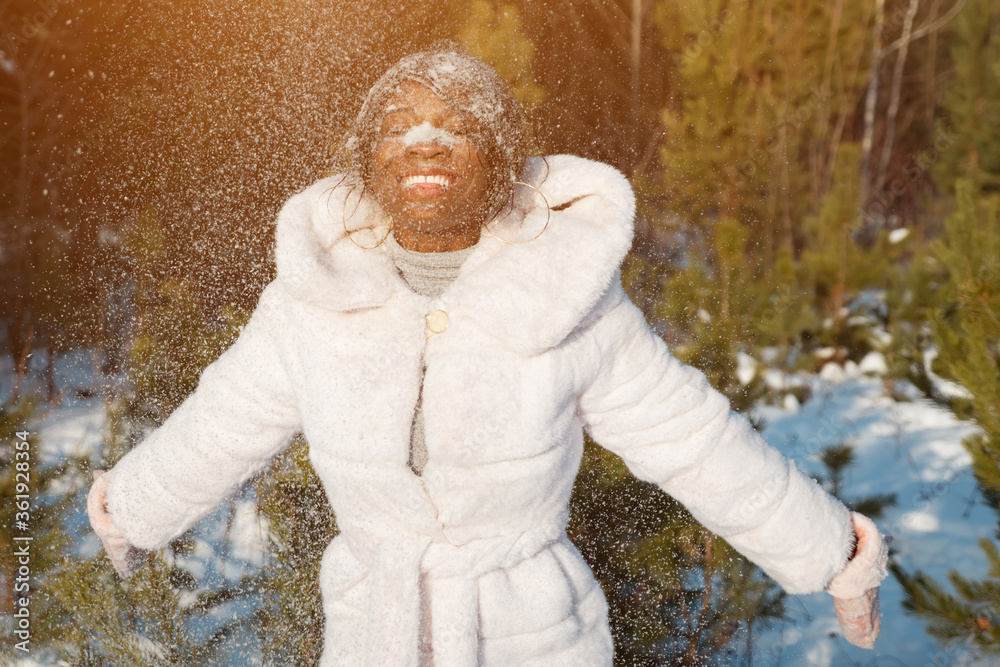 玩雪的深色皮肤女人撞到脸上，笑得阳光灿烂。