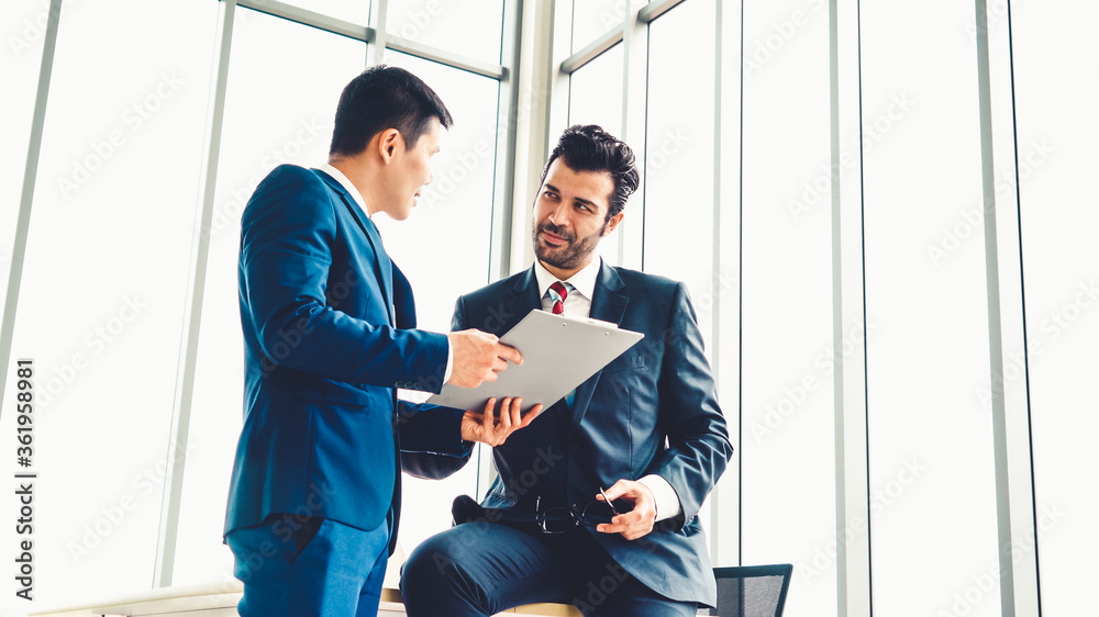 Two business people talk project strategy at office meeting room. Businessman discuss project planni