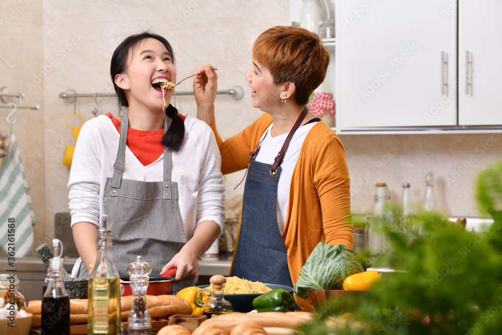 爱的亚洲家庭，母女在厨房烹饪，一起做健康的食物，感觉很好