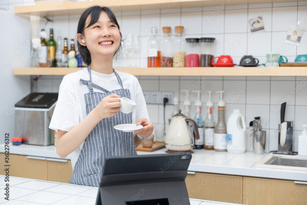 在厨房里，一边喝咖啡，一边用平板电脑，纯粹的女孩