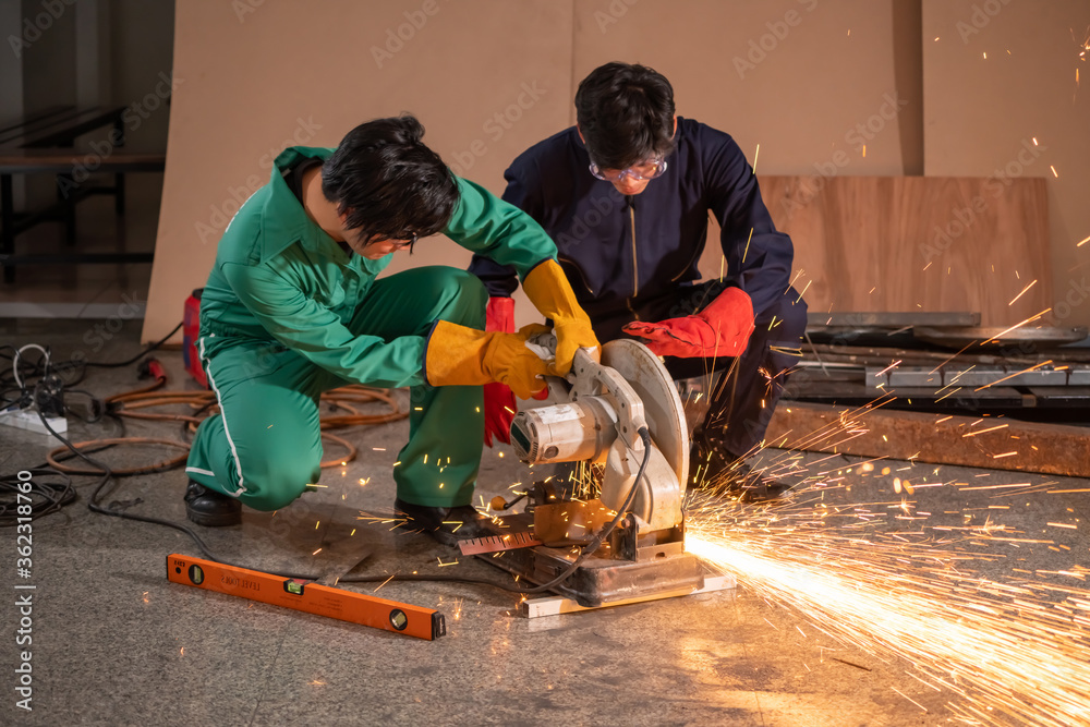 Professional mechanic man is cutting steel metal with rotating carbon blade cutter. Steel industry a