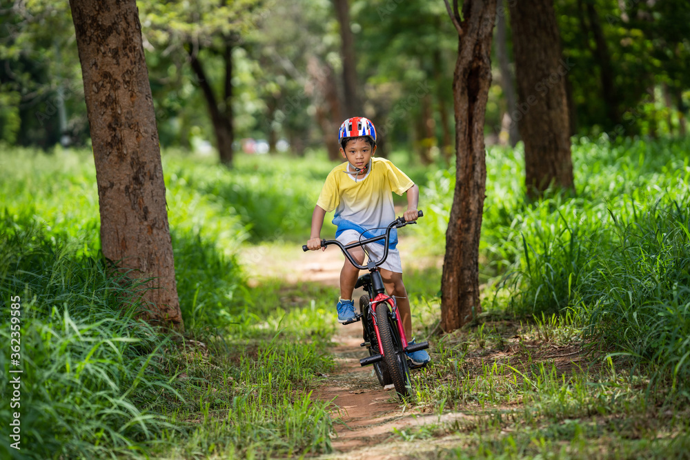 Asian boy is training for a happy mountain biking.