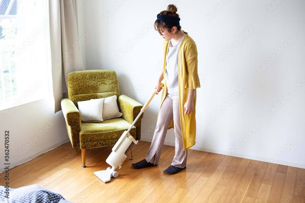 床に掃除機掛けをする女性
