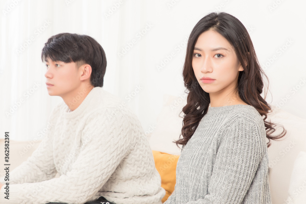 In winter, a pair of young Asian lovers sit on the sofa. Dont get angry

