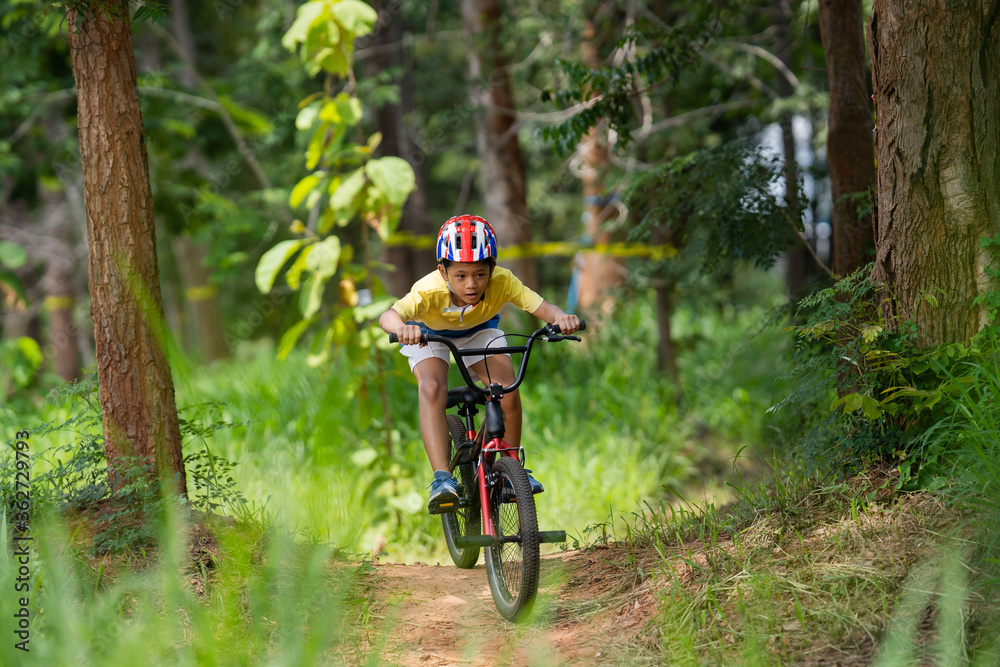 Asian boy is training for a happy mountain biking.