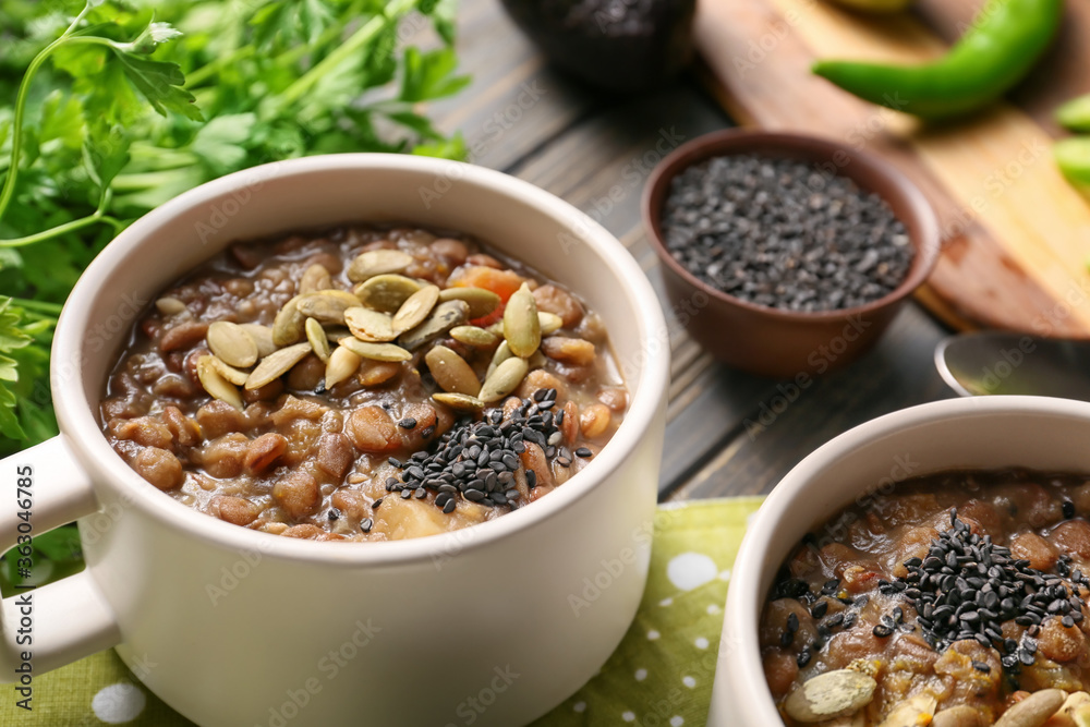 Cup of tasty lentils soup on table