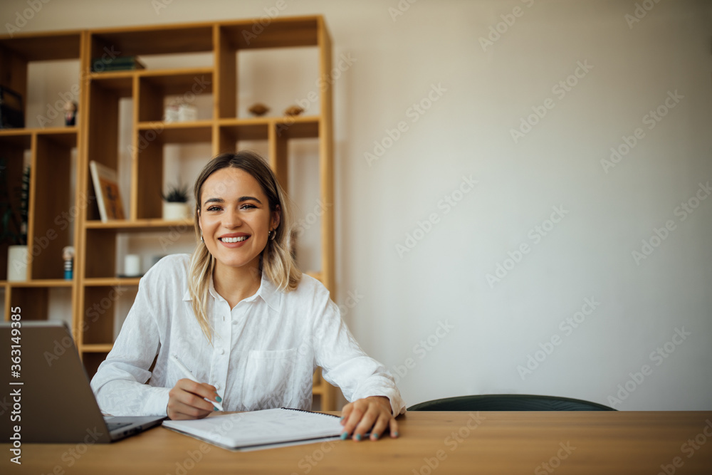 一位成功的女性作家在家庭办公室的肖像。