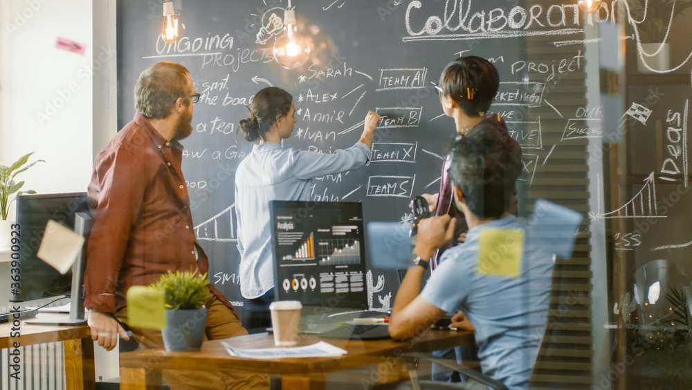 Diverse Team of Young Developers Draw Work Plan on a Blackboard Wall, Have Heated Discussion. Creati