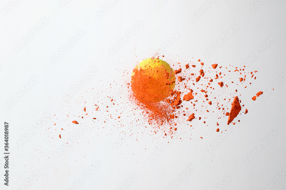 tennis ball with color powders on white background.