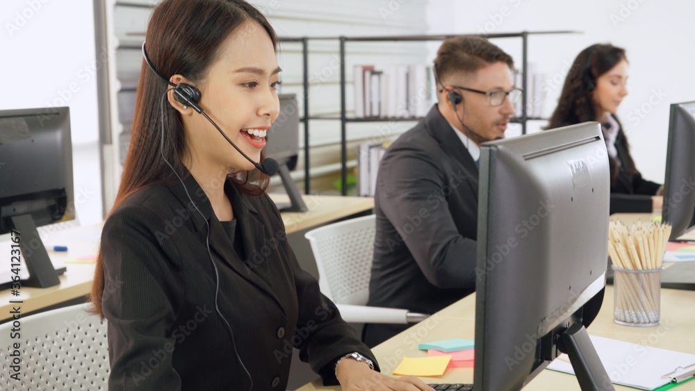 Business people wearing headset working in office to support remote customer or colleague. Call cent