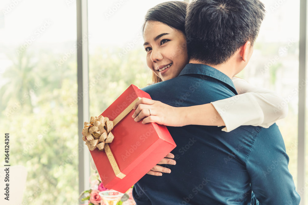 Romantic couple giving gift to lover at restaurant . Happy couple lifestyle .