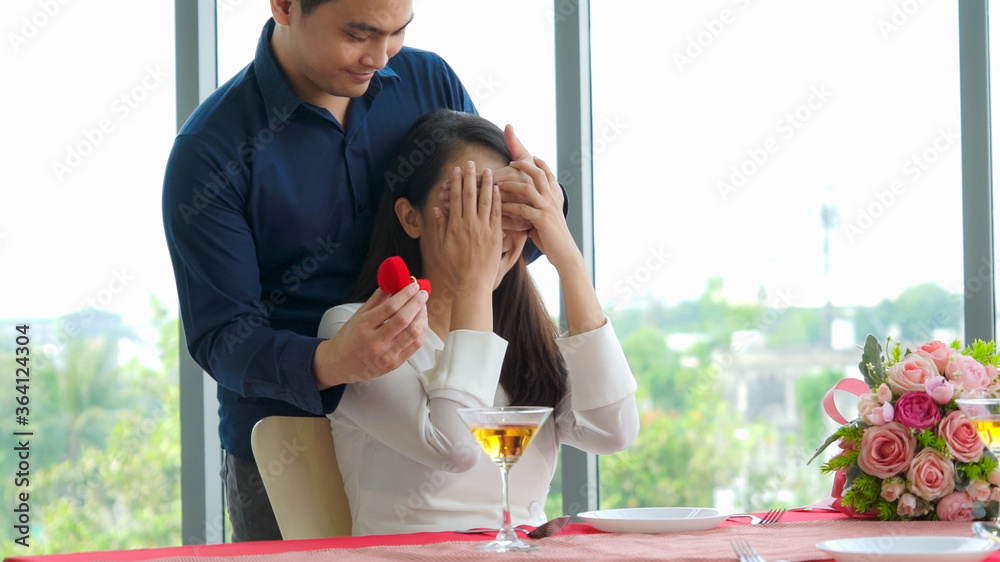 Romantic couple giving gift to lover at restaurant . Happy couple lifestyle .