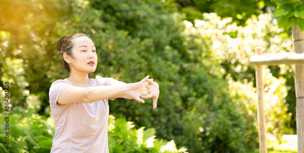 亚洲年轻女性在自然公园做瑜伽健身运动，健身运动或热身bo