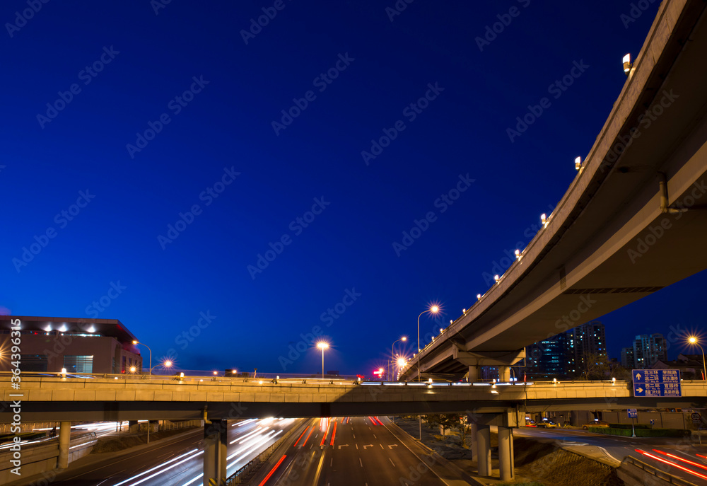 modern city with viaduct crossing over head at night in Beijing，blue background