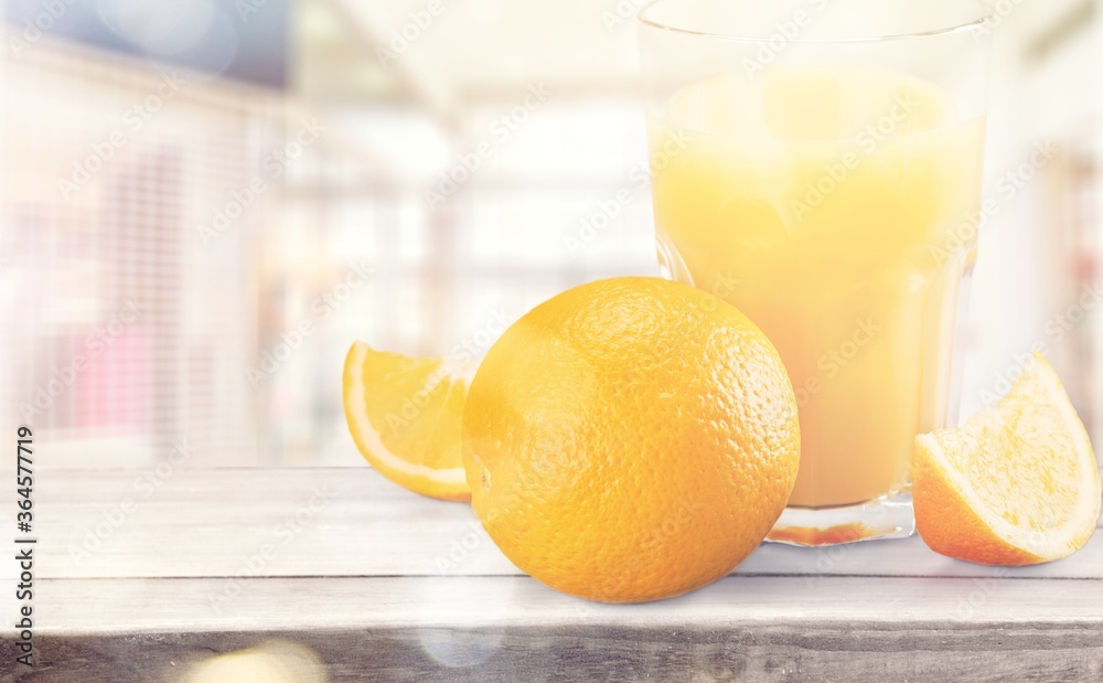 Orange juice and slices of orange on wooden desk