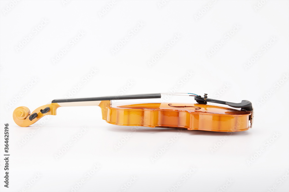 Wooden violins lie flat against a white background.