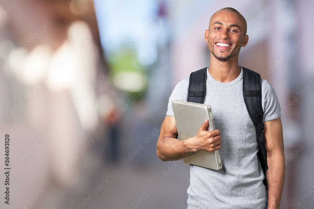 带着笔记本电脑微笑的年轻黑人大学生