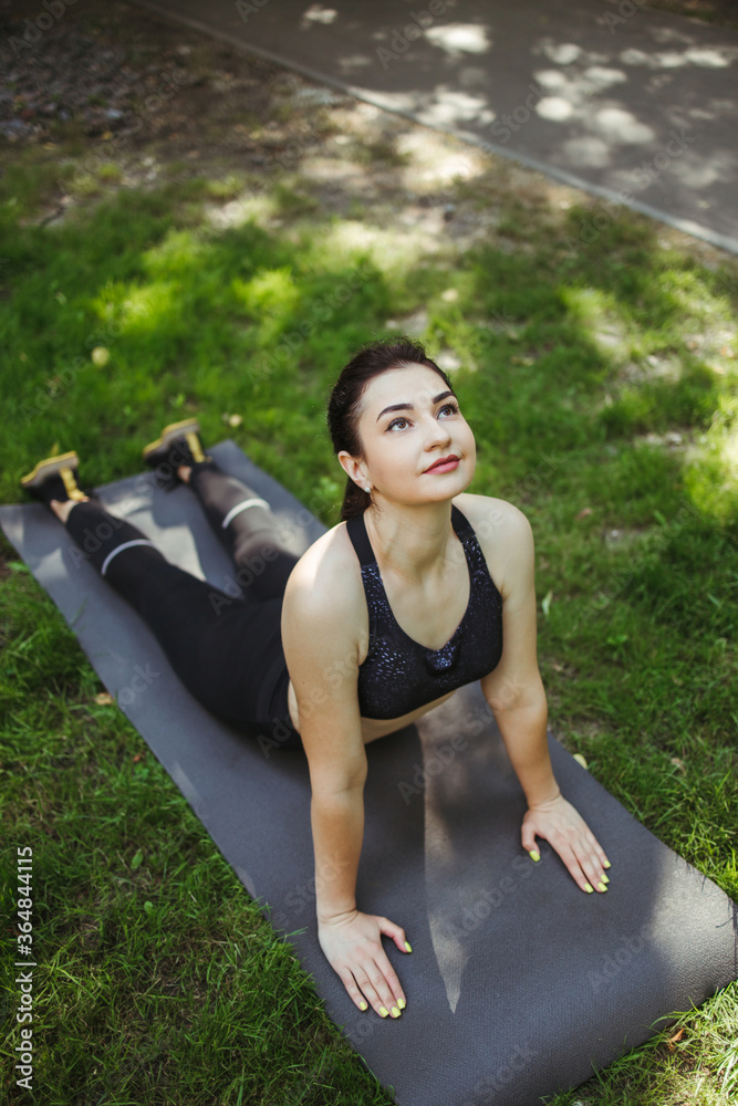 健康的女人在公园做晨练瑜伽。宁静专注。健康的生活方式