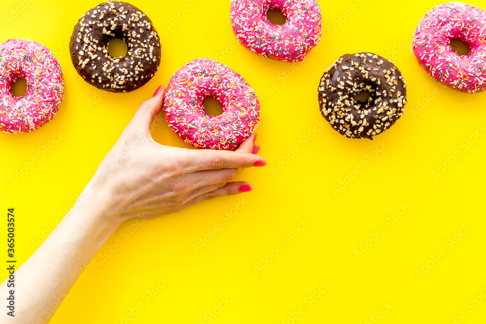 Hand holding glazed donut swith sprinkles, above view