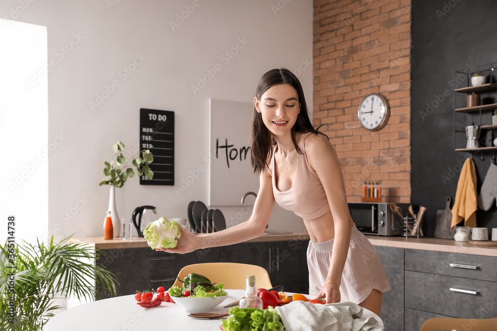 漂亮的年轻女人在厨房做蔬菜沙拉