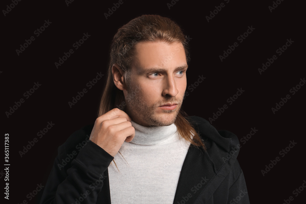 Handsome man with stylish hairdo on dark background