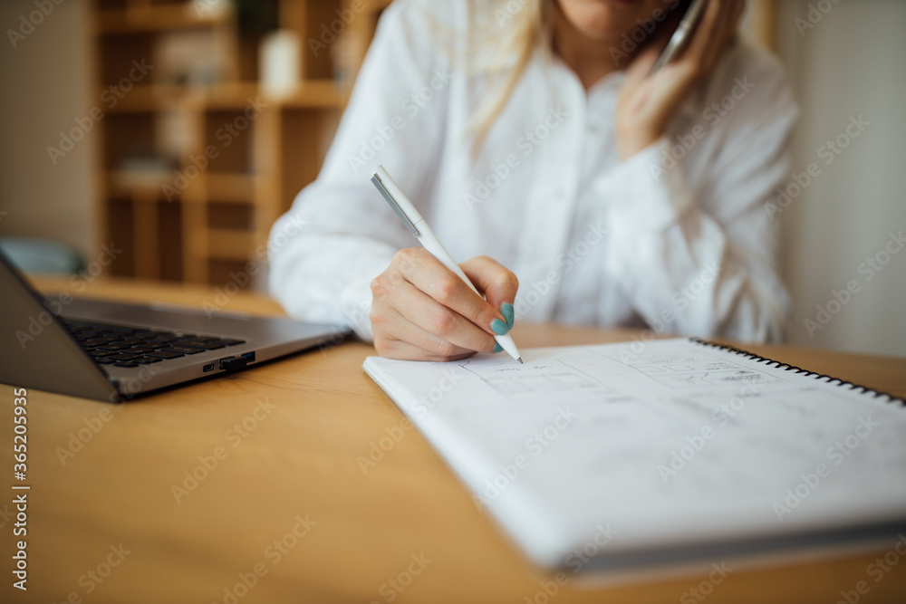 女人在笔记本上用笔写字。