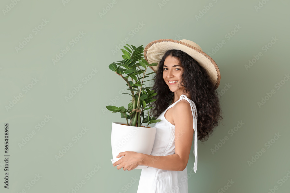 漂亮的年轻女人，彩色背景上有室内植物