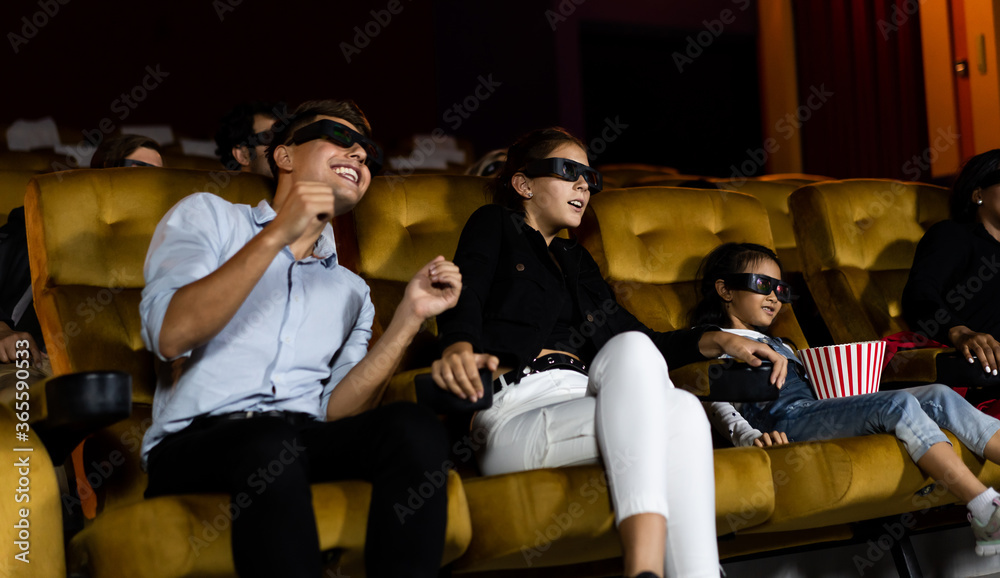 Group of people watch movie with 3D glasses in cinema theater with interest looking at the screen, e