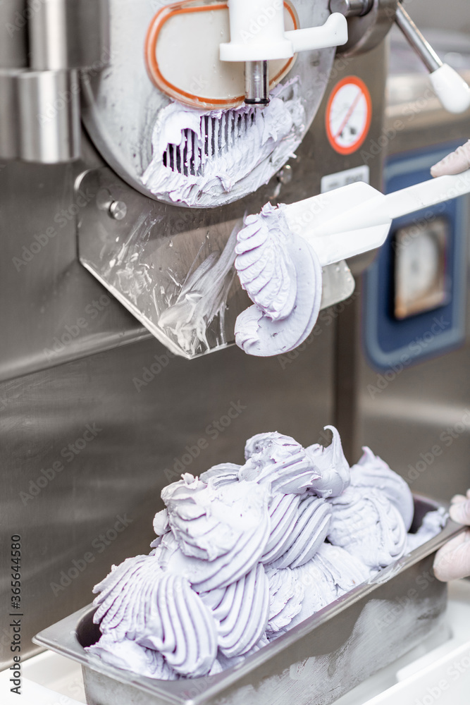 Pile of ready-made ice cream falling out of the freezer at the manufacturing, close-up