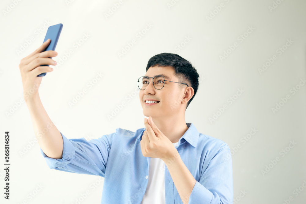 Man taking pictures sending korean style heart with his smartphone