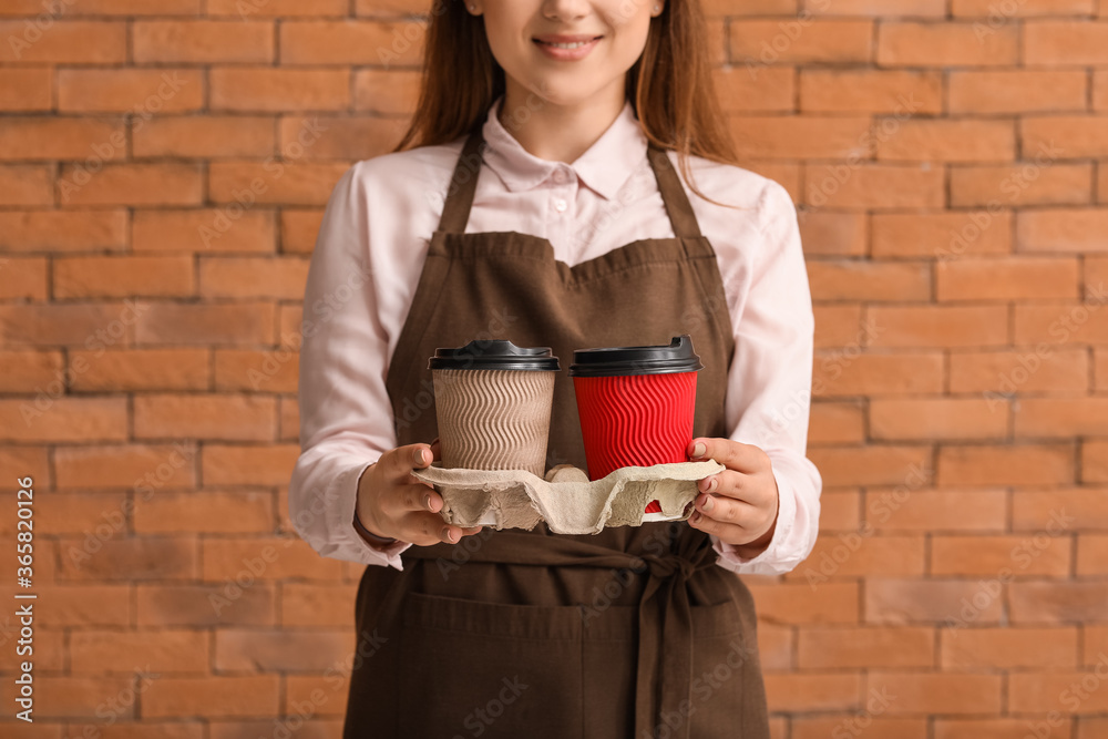 砖砌背景下的女咖啡师