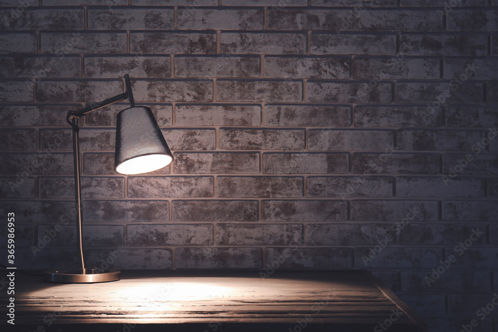 Glowing lamp on table in evening