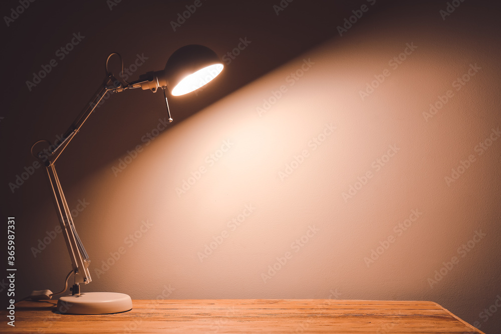 Glowing lamp on table in evening