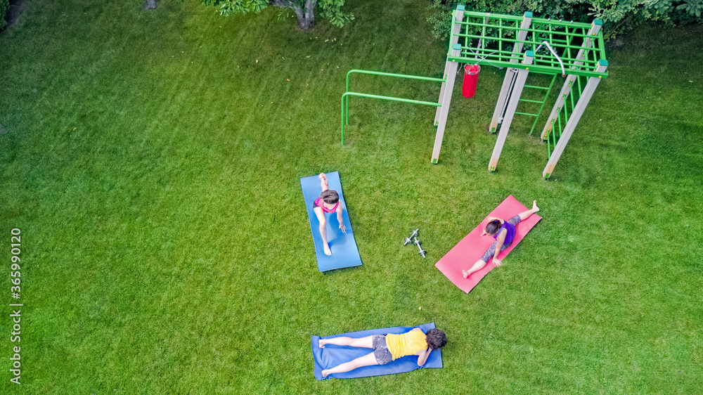 Family fitness and sport outdoors, active mother and children doing workout in park aerial top view 