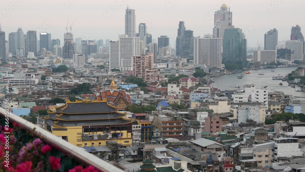 东方城市的传统和现代建筑景观。美丽的花坛映衬着城市景观