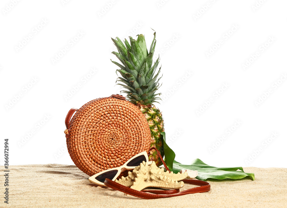 Beach accessories on sand against white background