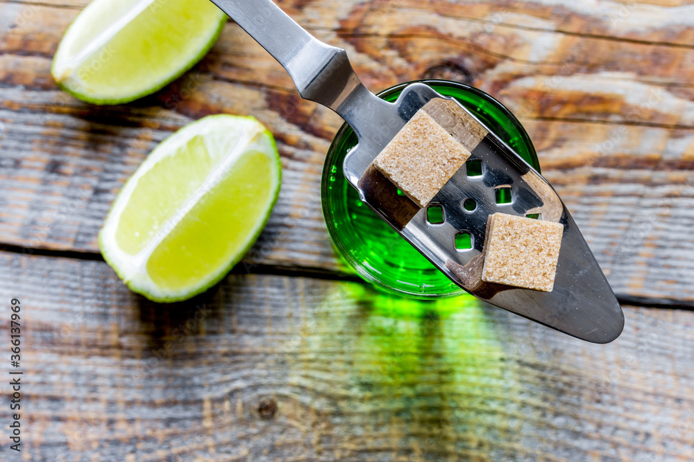 absinthe shots with lime slices and sugar on dark table background top view