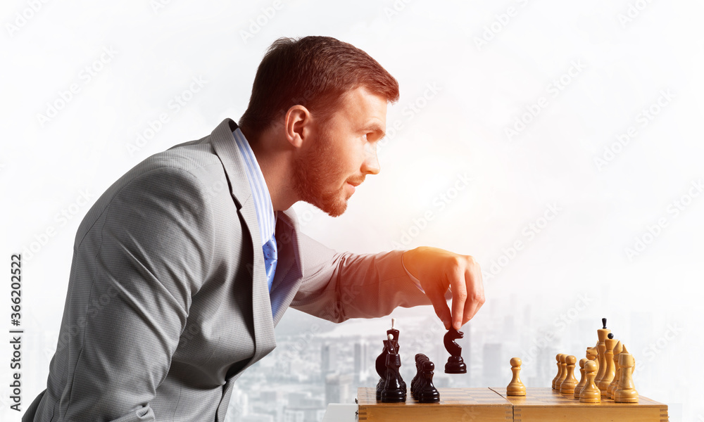 Businessman moving chess figure in chessboard