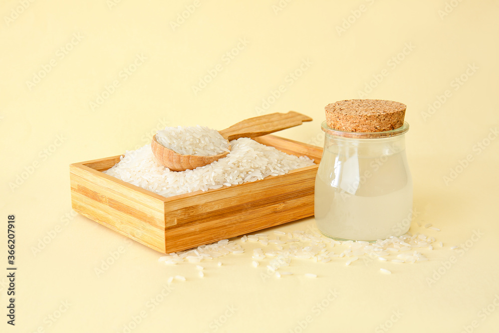 Jar of rice water on color background