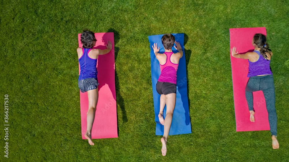 Family fitness and sport outdoors, group of active girls doing workout in park, aerial top view from