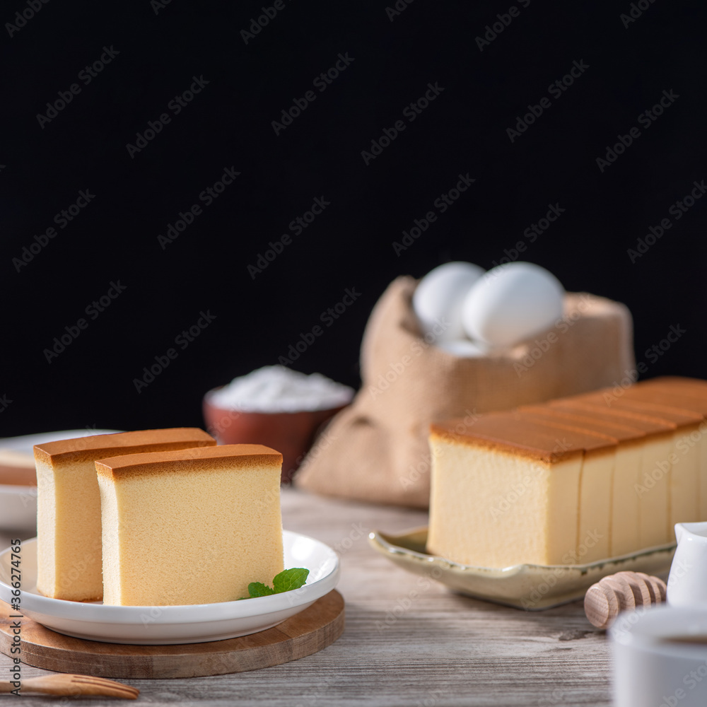 Castella（kasutera）-美味的日本切片海绵蛋糕食品，放在乡村木t上的白色盘子里